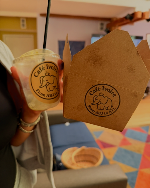 Hands holding Café Ivoire coffee cup